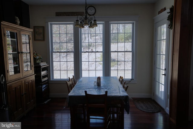 dining area with baseboards, a chandelier, and dark wood finished floors