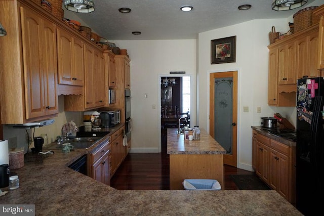 kitchen with a center island, baseboards, freestanding refrigerator, brown cabinets, and dark wood-style floors