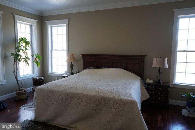 bedroom featuring ornamental molding, dark wood-type flooring, baseboards, and multiple windows