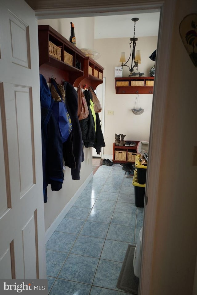 mudroom with baseboards, a chandelier, and tile patterned floors