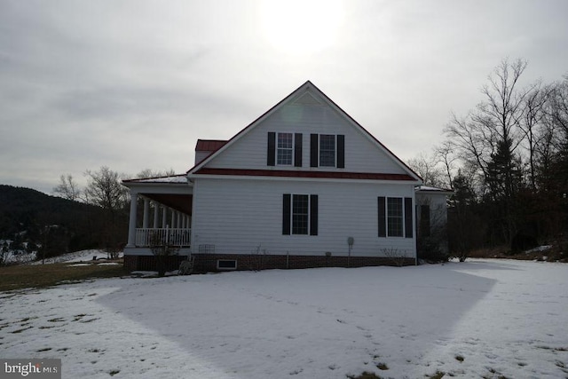 view of snow covered back of property