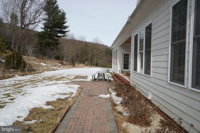 yard covered in snow featuring a patio area