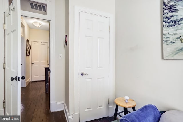 interior space featuring baseboards, visible vents, and dark wood-style flooring