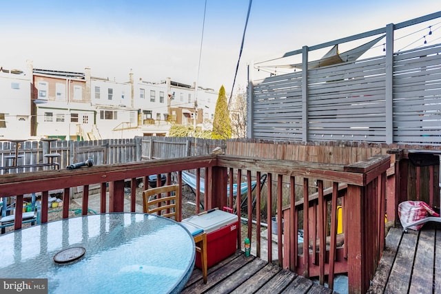 deck featuring outdoor dining space, fence, and a residential view