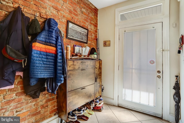 tiled entrance foyer with brick wall