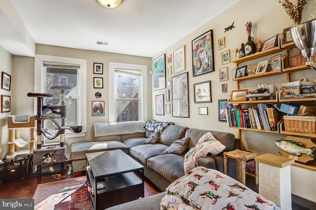 living area featuring visible vents and wood finished floors