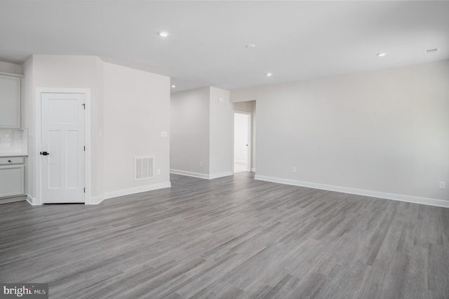 unfurnished living room featuring recessed lighting, visible vents, light wood-style flooring, and baseboards