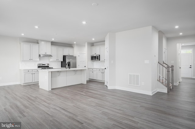 kitchen with appliances with stainless steel finishes, light countertops, white cabinets, and visible vents