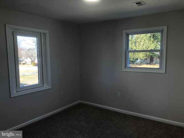 carpeted empty room with a wealth of natural light, visible vents, and baseboards