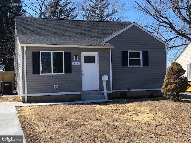 view of front of house featuring entry steps, a shingled roof, and central AC