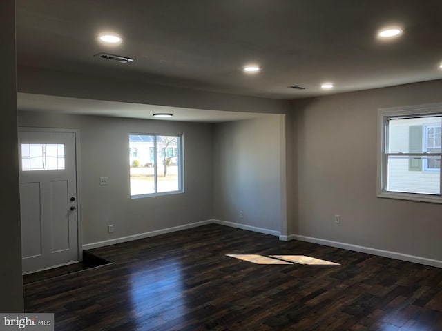 foyer entrance with baseboards, visible vents, dark wood-style flooring, and recessed lighting