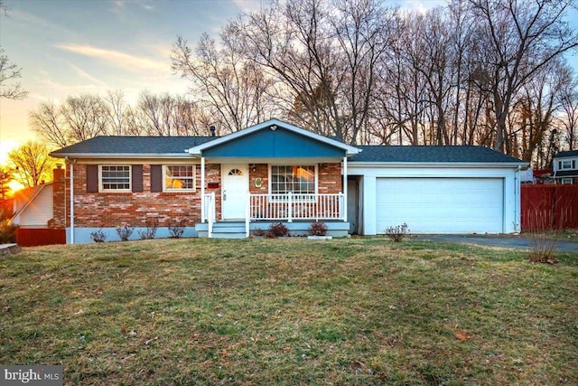 ranch-style home with brick siding, covered porch, an attached garage, driveway, and a front lawn