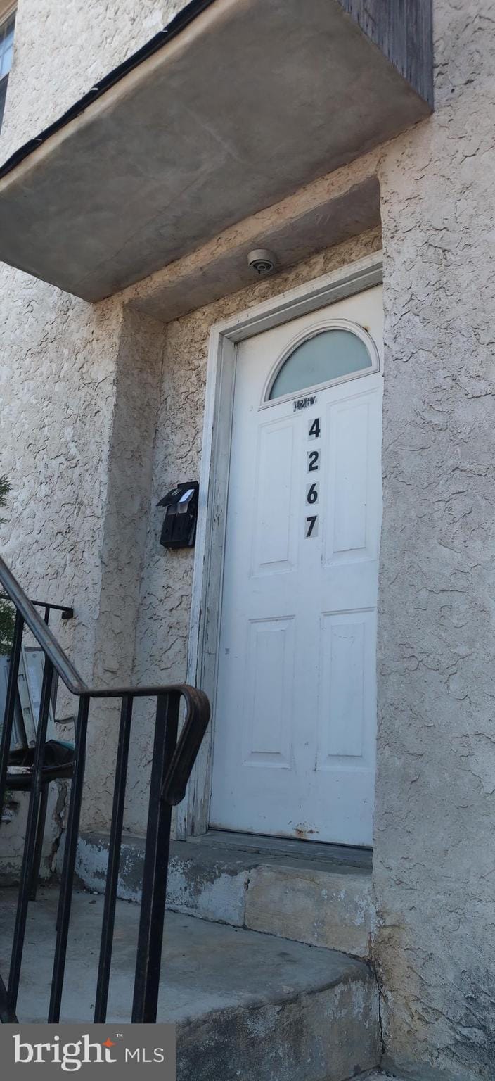 property entrance with stucco siding