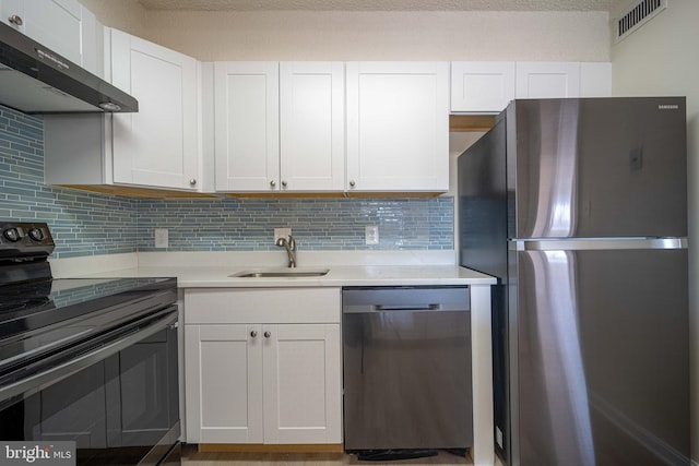 kitchen with range hood, stainless steel appliances, light countertops, white cabinets, and a sink