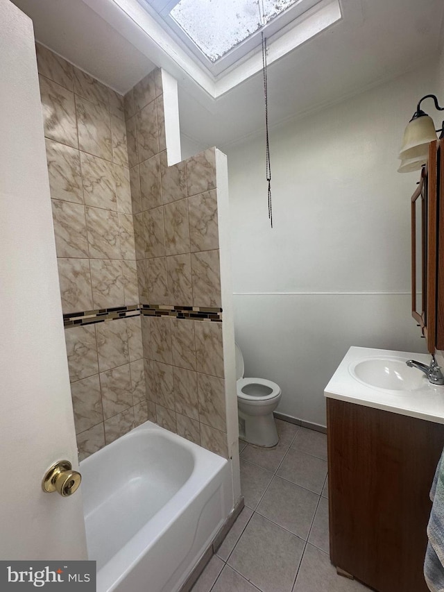 full bathroom featuring a skylight, tile patterned floors, vanity, and toilet