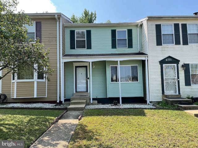 townhome / multi-family property featuring entry steps and a front lawn