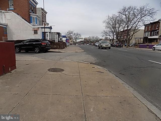 view of street with sidewalks, a residential view, and curbs