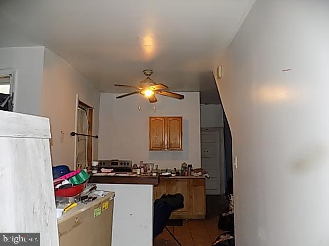 kitchen with a ceiling fan, dark countertops, and light tile patterned floors