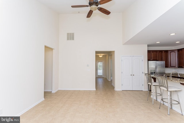 kitchen with dark brown cabinets, a breakfast bar, visible vents, and baseboards