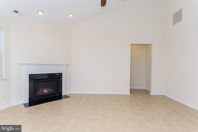 unfurnished living room with a fireplace with flush hearth, visible vents, and baseboards