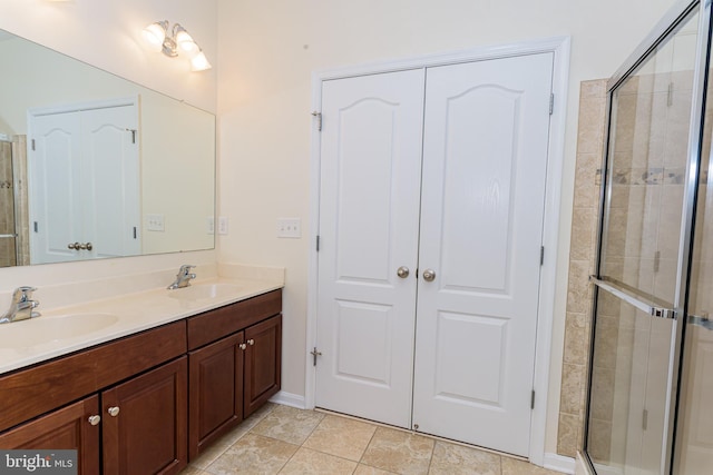 full bathroom with a tile shower, double vanity, a sink, and tile patterned floors