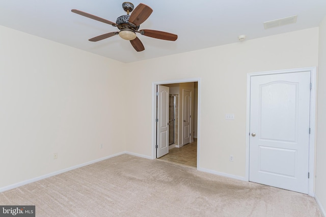 unfurnished bedroom with light carpet, baseboards, visible vents, and a ceiling fan