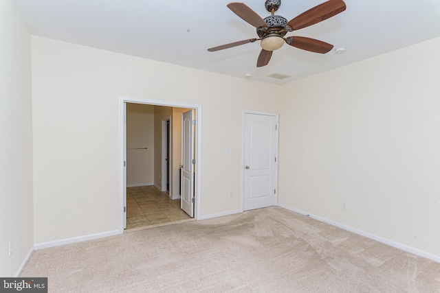 unfurnished bedroom with light carpet, visible vents, baseboards, and a ceiling fan