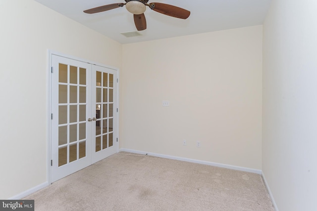 empty room featuring visible vents, baseboards, a ceiling fan, light colored carpet, and french doors