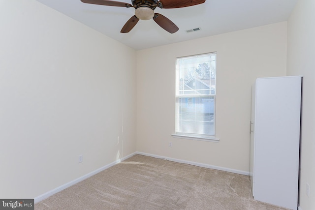 empty room featuring baseboards, visible vents, and light colored carpet