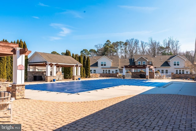 community pool featuring a residential view, a patio, and a gazebo