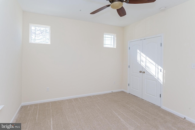 entrance foyer with light carpet, baseboards, and a ceiling fan