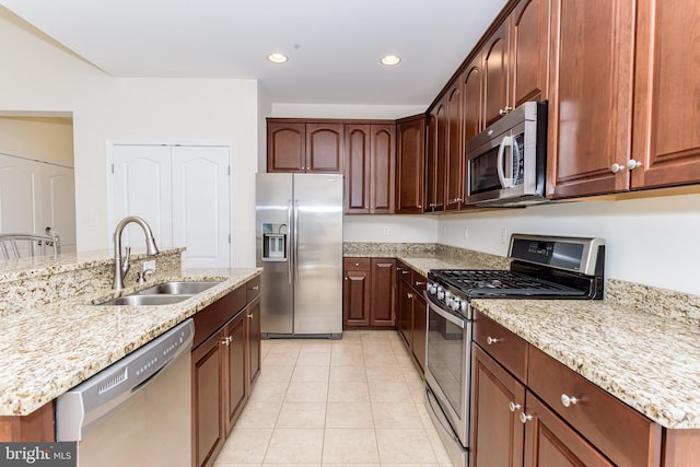 kitchen with light tile patterned floors, light stone counters, recessed lighting, a sink, and appliances with stainless steel finishes