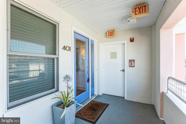 entrance to property with covered porch and stucco siding