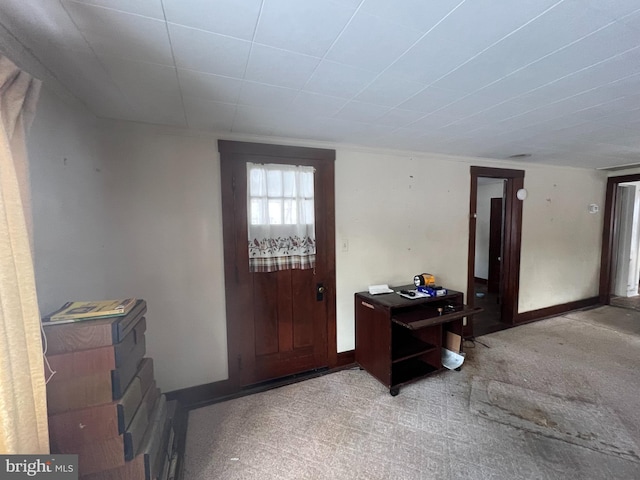 foyer entrance featuring light carpet and baseboards