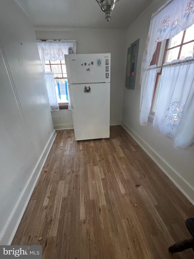 interior space featuring wood finished floors, electric panel, and baseboards