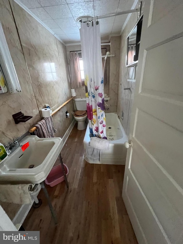 full bathroom featuring toilet, a shower with curtain, crown molding, and wood finished floors