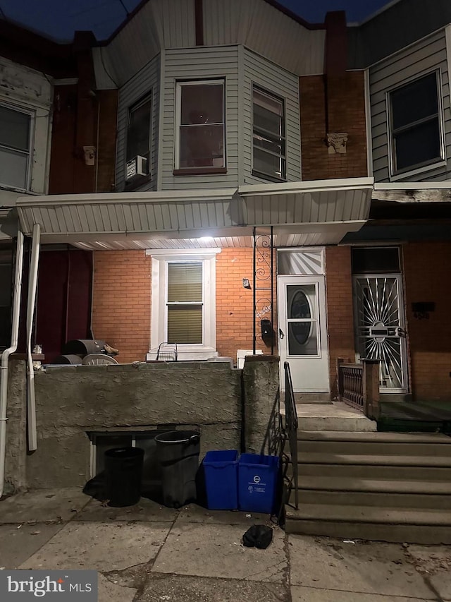 entrance to property featuring cooling unit and brick siding