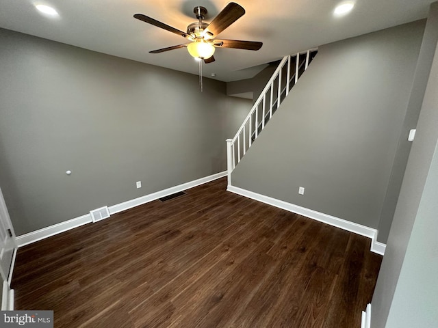 below grade area featuring dark wood-type flooring, stairway, visible vents, and baseboards