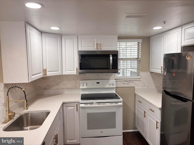 kitchen featuring light countertops, appliances with stainless steel finishes, a sink, and white cabinetry