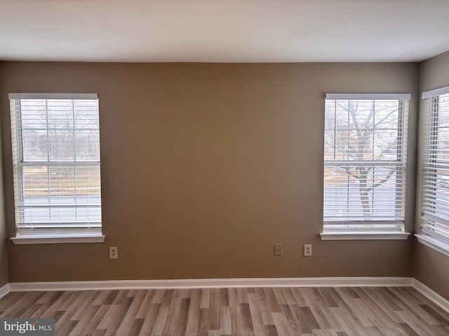 spare room featuring wood finished floors and baseboards