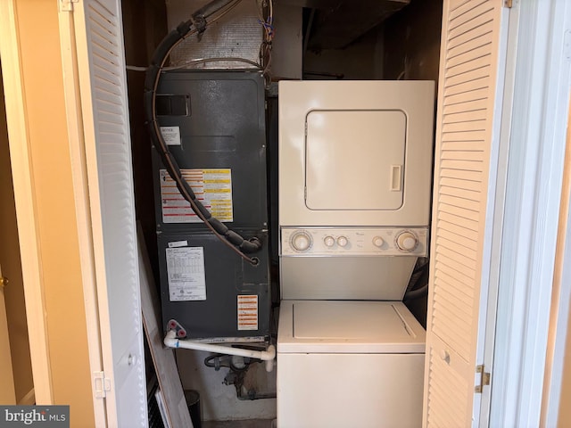 washroom featuring stacked washer and dryer and laundry area