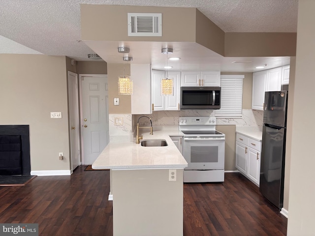 kitchen with visible vents, decorative light fixtures, stainless steel appliances, white cabinetry, and a sink