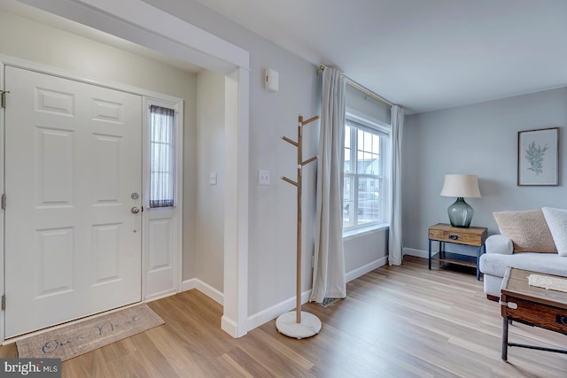 foyer with light wood-style flooring and baseboards