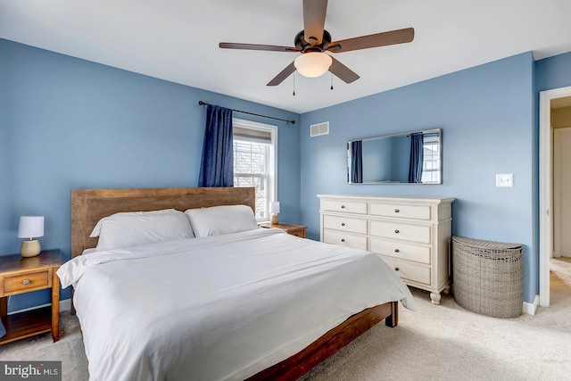 bedroom featuring light carpet, baseboards, visible vents, and a ceiling fan