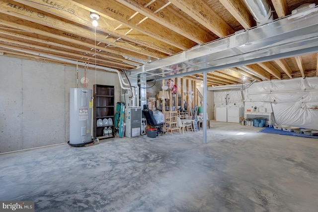 unfinished below grade area featuring water heater and independent washer and dryer