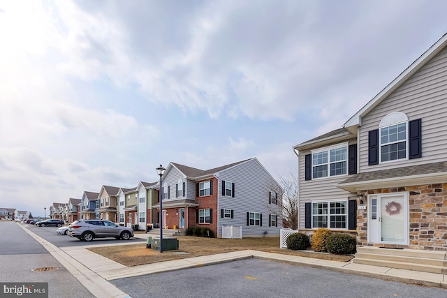 view of road with sidewalks, a residential view, and curbs