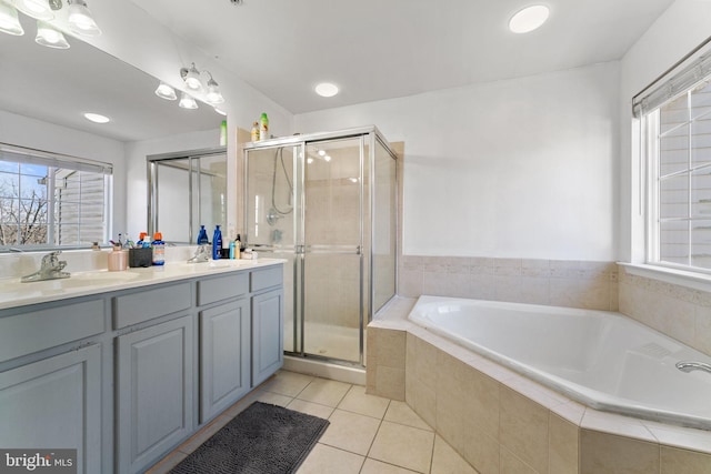 bathroom featuring a stall shower, a sink, tile patterned flooring, double vanity, and a bath