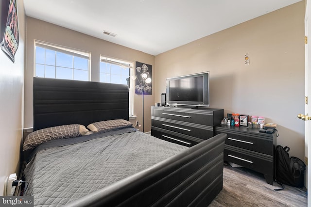 bedroom with visible vents and wood finished floors