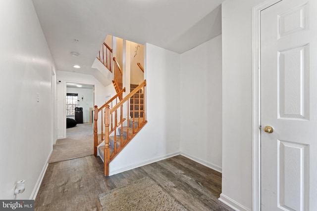 stairway with wood finished floors and baseboards