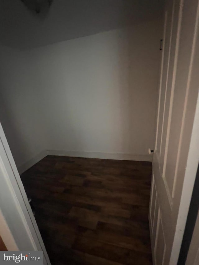 empty room featuring dark wood-style flooring and baseboards